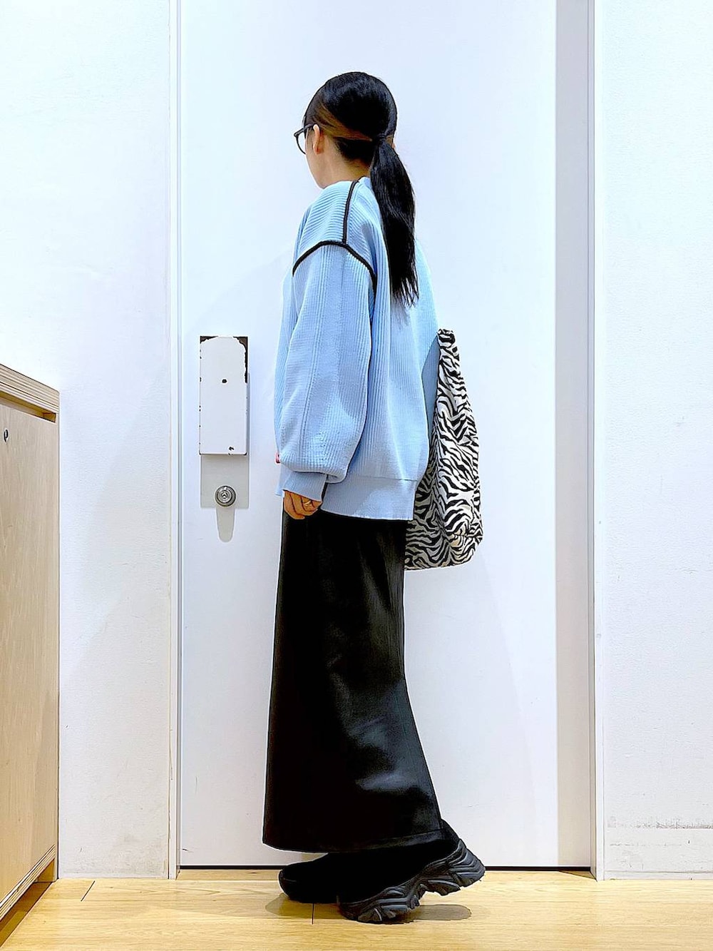 グレー系のTシャツ/カットソー、ブラック系のブーツ、その他のトートバッグを着用したレディースの春コーディネートの3枚目の写真