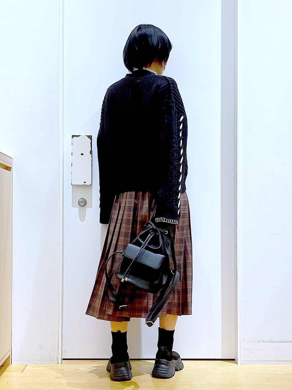 ブラック系のニット/セーター、ブラック系のバックパック/リュック、ブラック系のブーツを着用したレディースの冬コーディネートの5枚目の写真