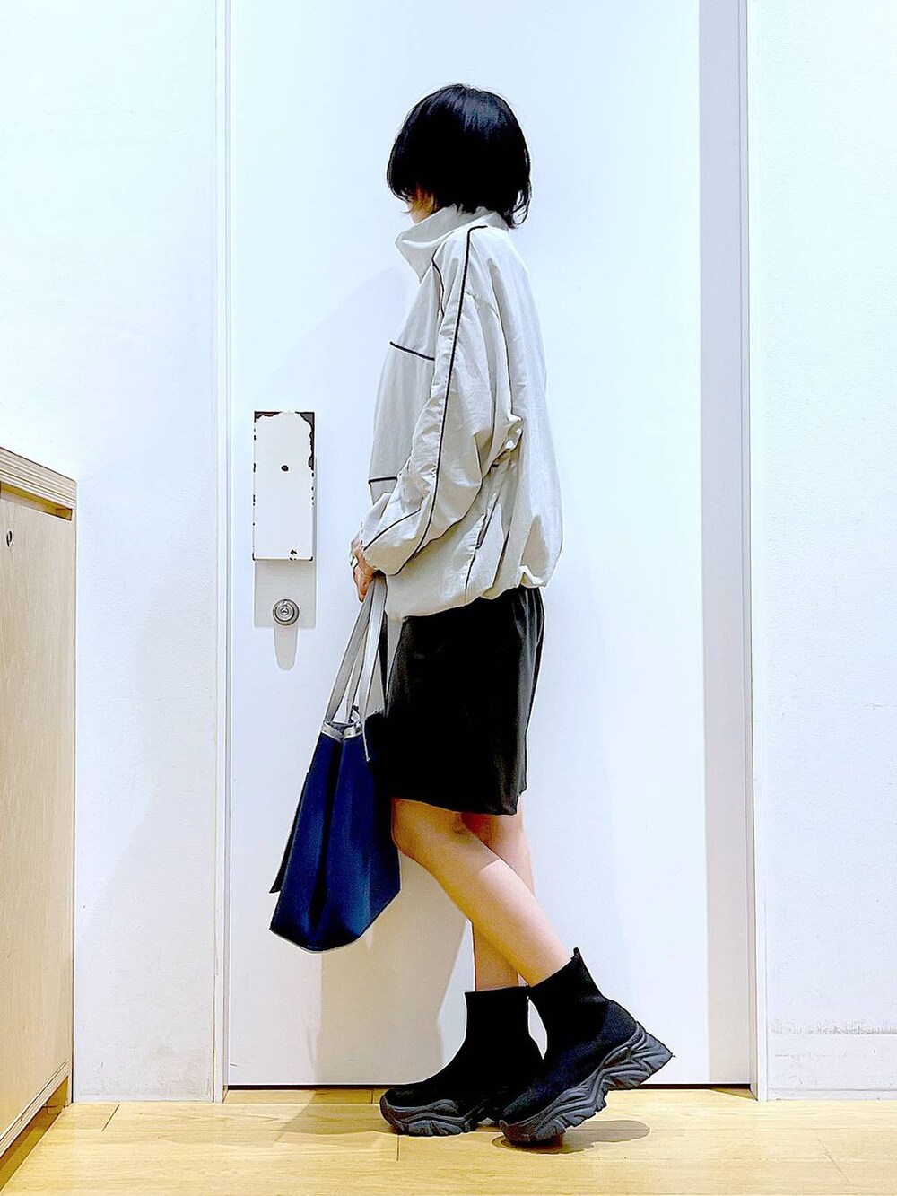 ブラック系のブーツ、ブルー系のトートバッグ、グレー系のブルゾンを着用したレディースの冬コーディネートの3枚目の写真