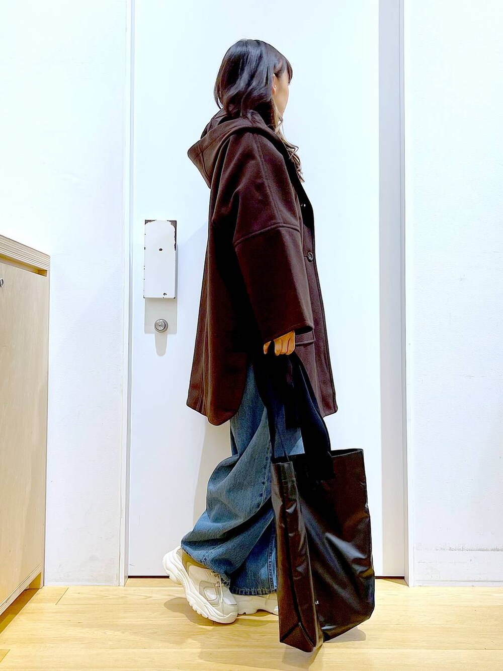 ブラウン系のその他アウター、ベージュ系のスニーカー、ブルー系のデニムパンツを着用したレディースの冬コーディネートの4枚目の写真