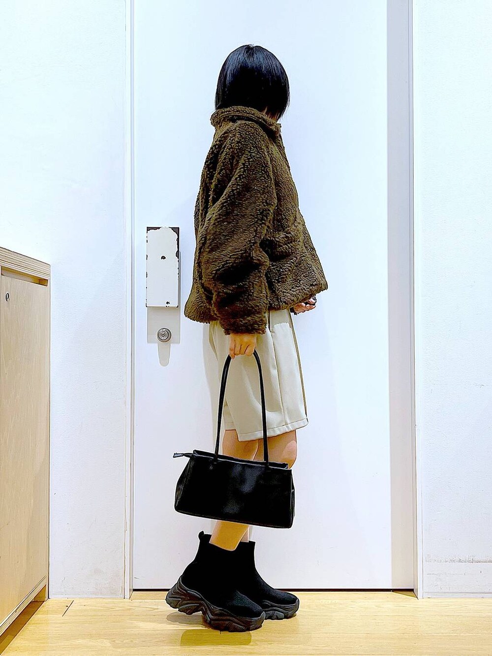 ブルー系のニット/セーター、ブラック系のトートバッグ、ブラック系のブーツを着用したレディースの冬コーディネートの4枚目の写真