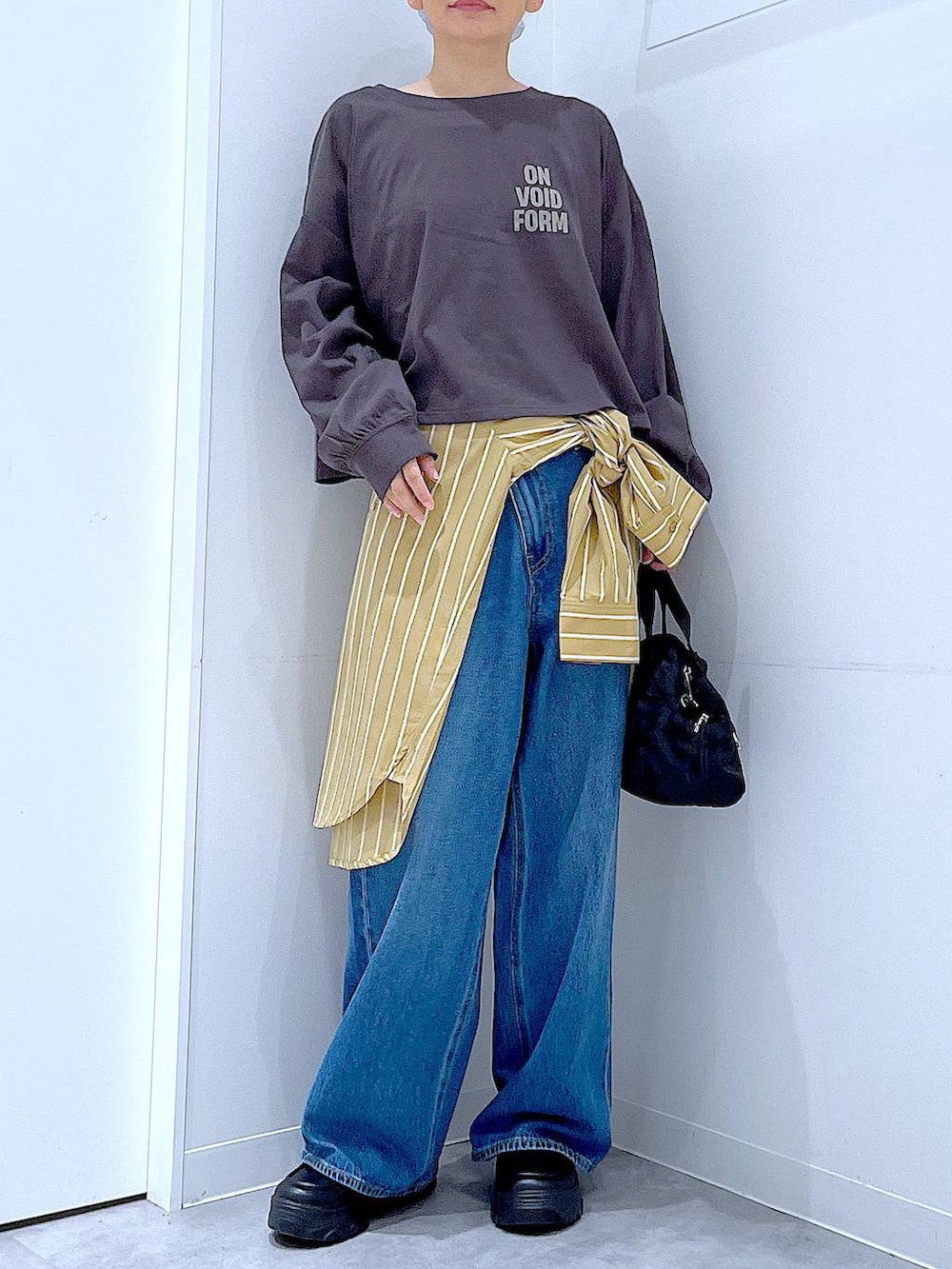 ブルー系のデニムパンツ、イエロー系のシャツ/ブラウス、グレー系のTシャツ/カットソーを着用したレディースの秋コーディネートの6枚目の写真