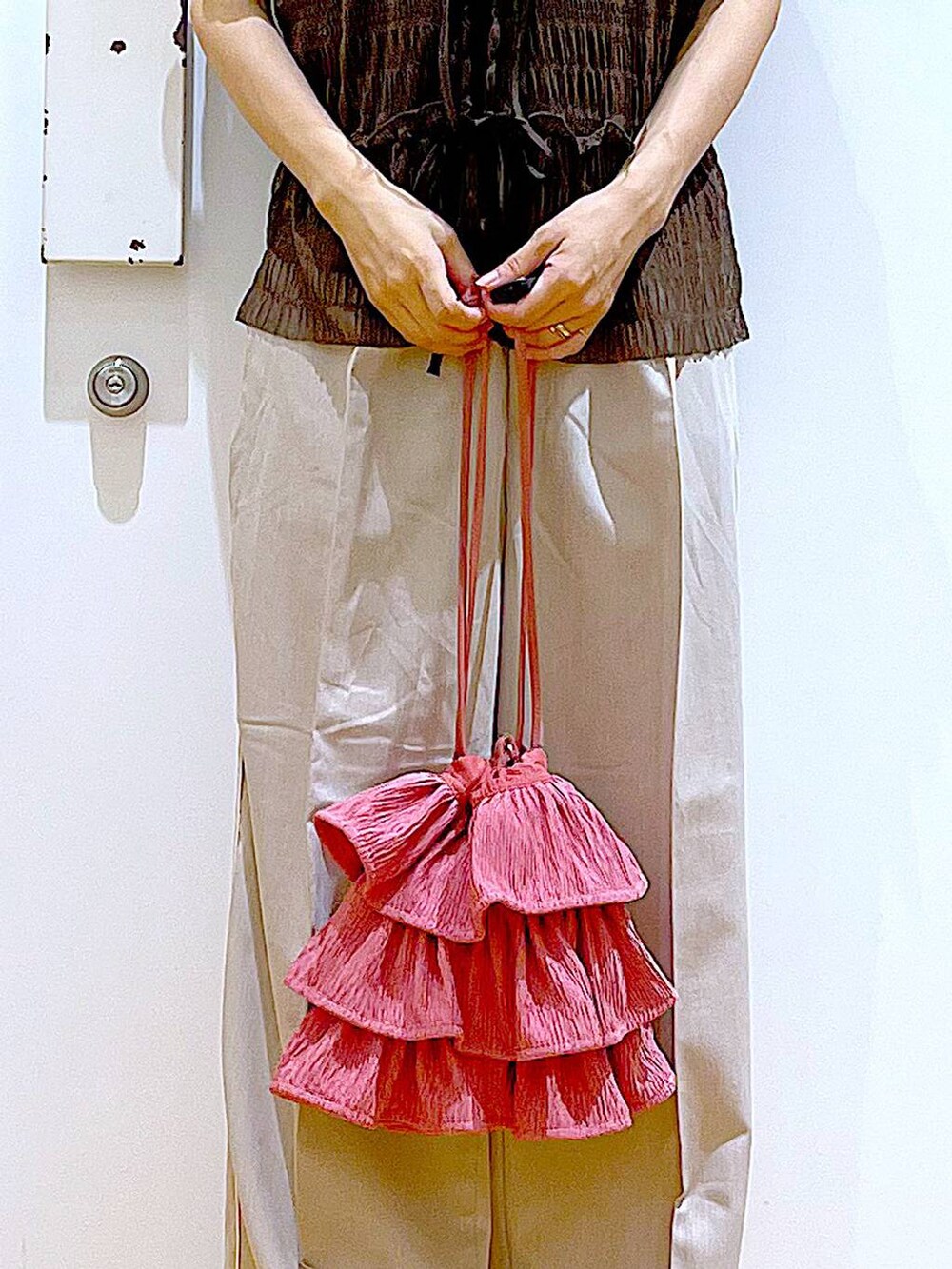 ホワイト系のサンダル、ベージュ系のスラックス、ピンク系のショルダーバッグを着用したレディースの秋コーディネートの9枚目の写真