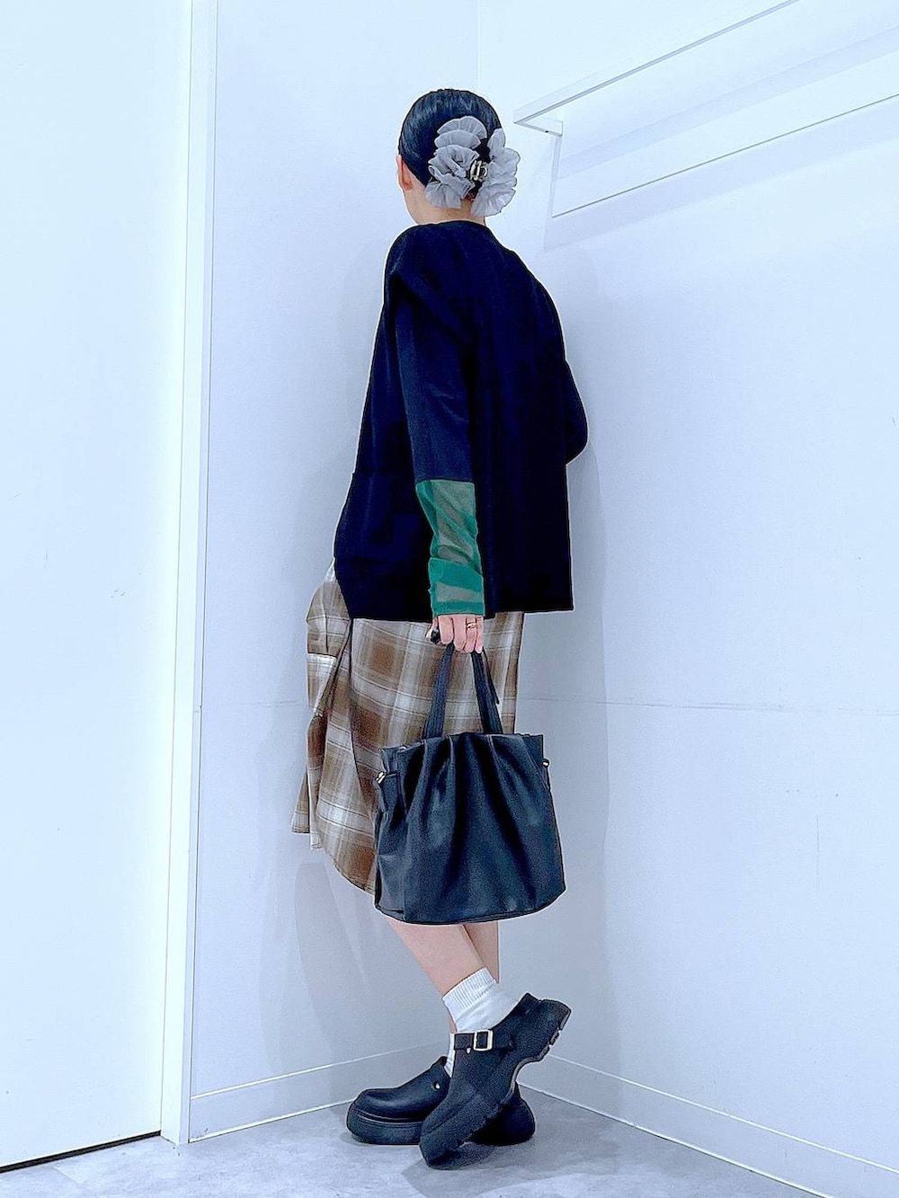 ブラウン系のシャツ/ブラウス、ブラック系のTシャツ/カットソー、ブラック系のハンドバッグを着用したレディースの秋コーディネートの3枚目の写真