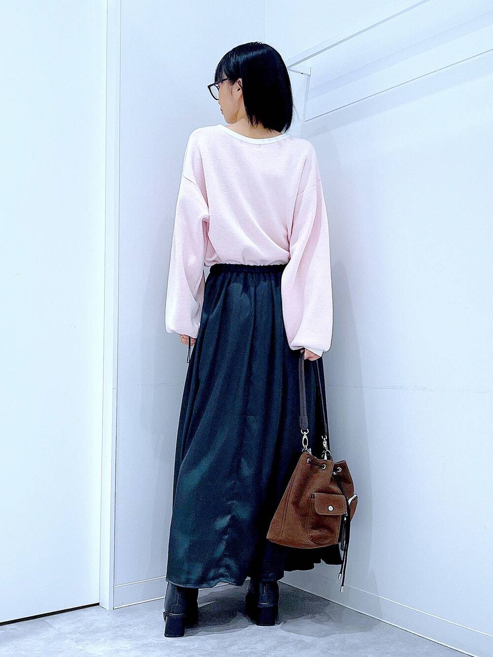 ブラウン系のショルダーバッグ、ブラック系のブーツ、ベージュ系のニット/セーターを着用したレディースの冬コーディネートの5枚目の写真