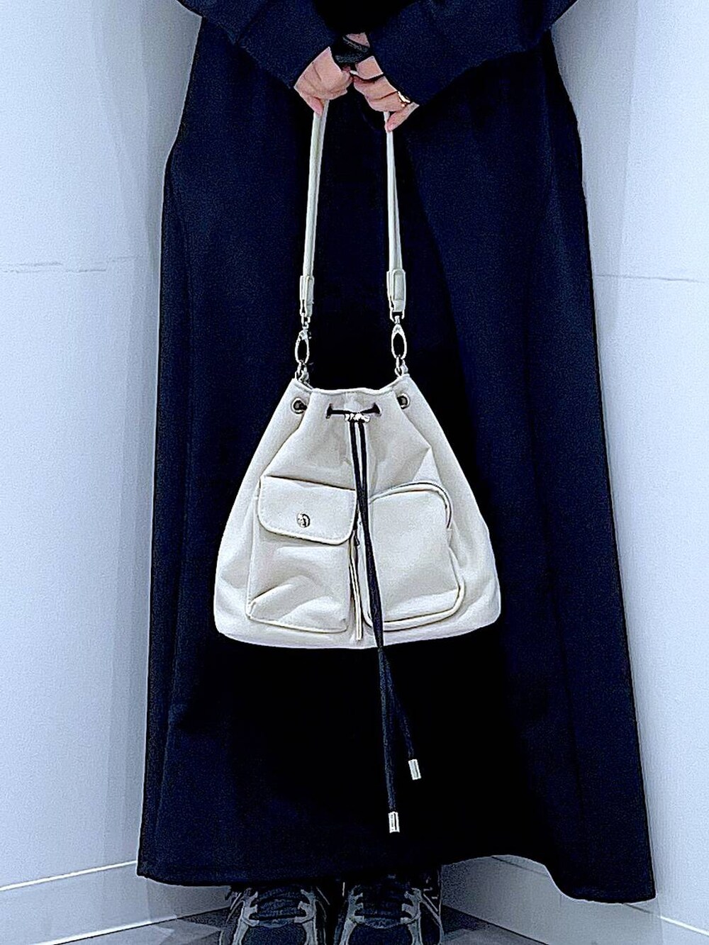 ベージュ系のショルダーバッグ、ブラック系のスウェット、ブラック系のスカートを着用したレディースの春コーディネートの9枚目の写真