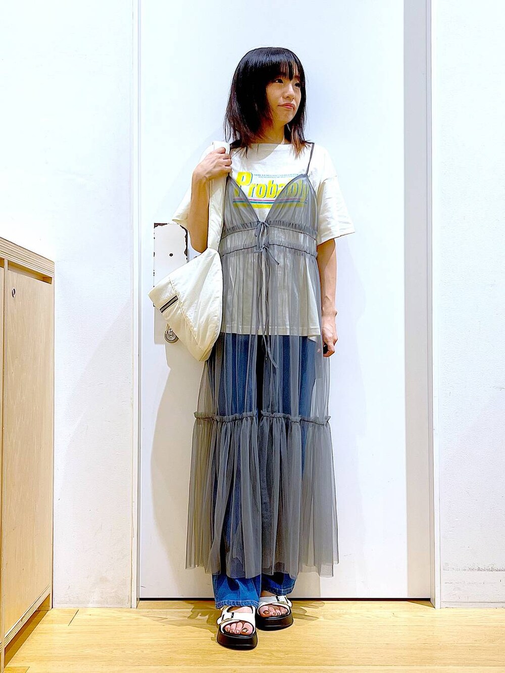 ブルー系のデニムパンツ、グレー系のワンピース、ベージュ系のTシャツ/カットソーを着用したレディースの夏コーディネートの2枚目の写真