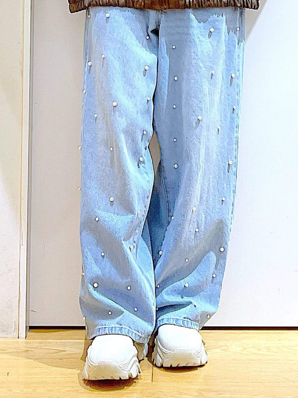 ブラウン系のブルゾン、ベージュ系のブーツ、ブルー系のデニムパンツを着用したレディースの秋コーディネートの8枚目の写真