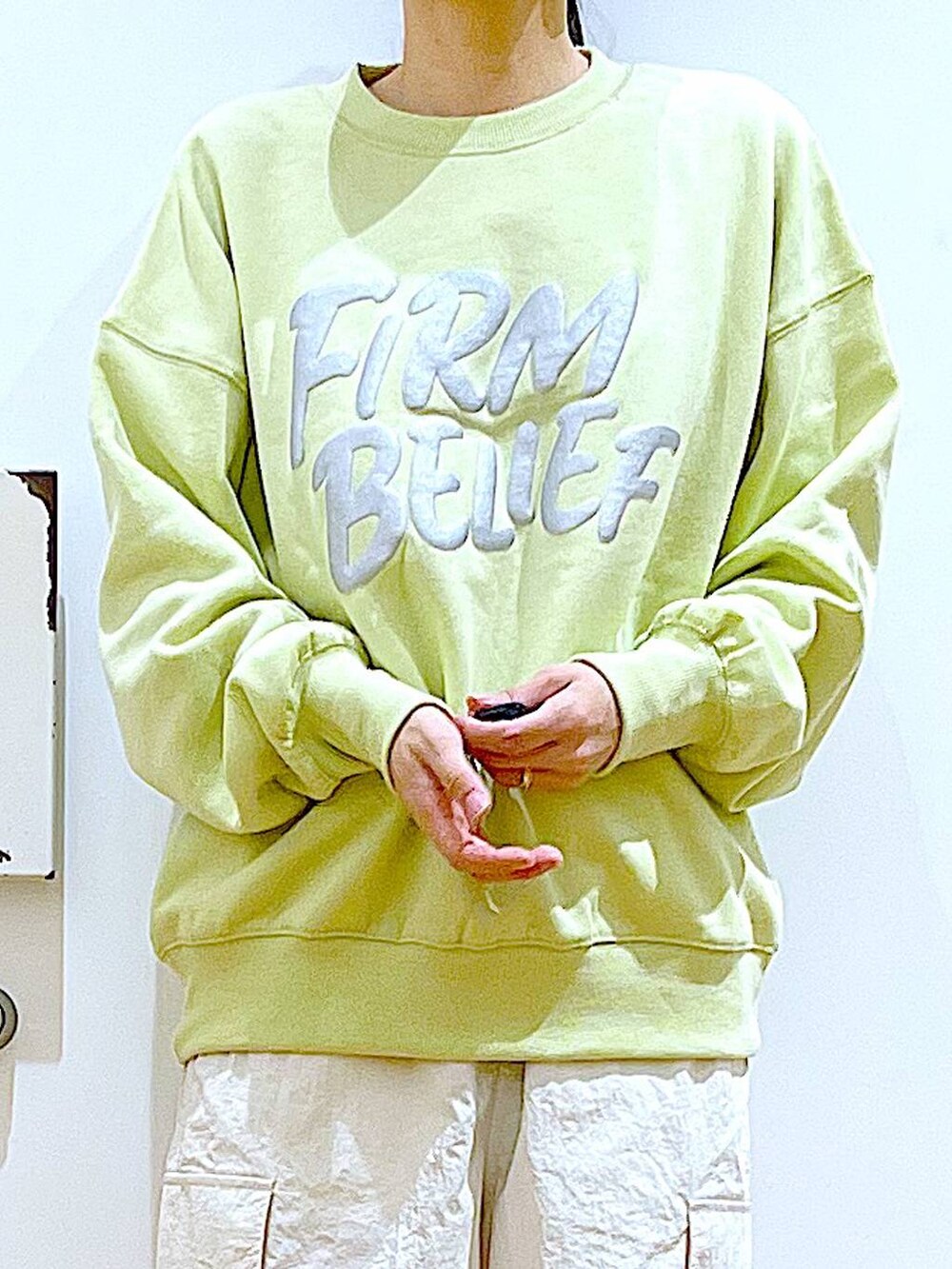 イエロー系のスウェット、ベージュ系のブーツ、その他のショルダーバッグを着用したレディースの春コーディネートの7枚目の写真