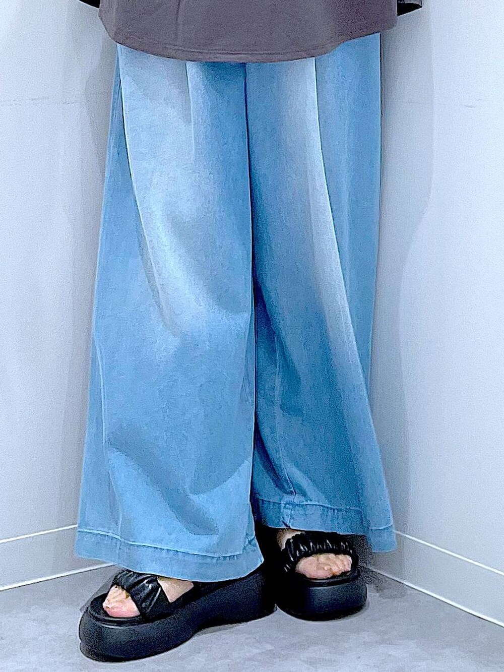 ブラック系のショルダーバッグ、ブラック系のサンダル、ブルー系のデニムパンツを着用したレディースの夏コーディネートの8枚目の写真