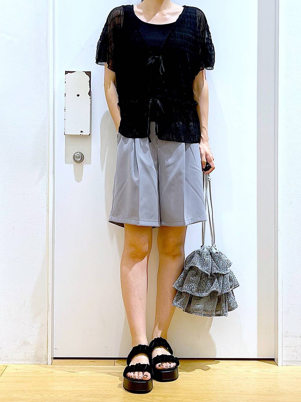 シルバー系のショルダーバッグ、グレー系のその他パンツ、ブラック系のサンダルを着用したレディースの夏コーディネートの6枚目の写真