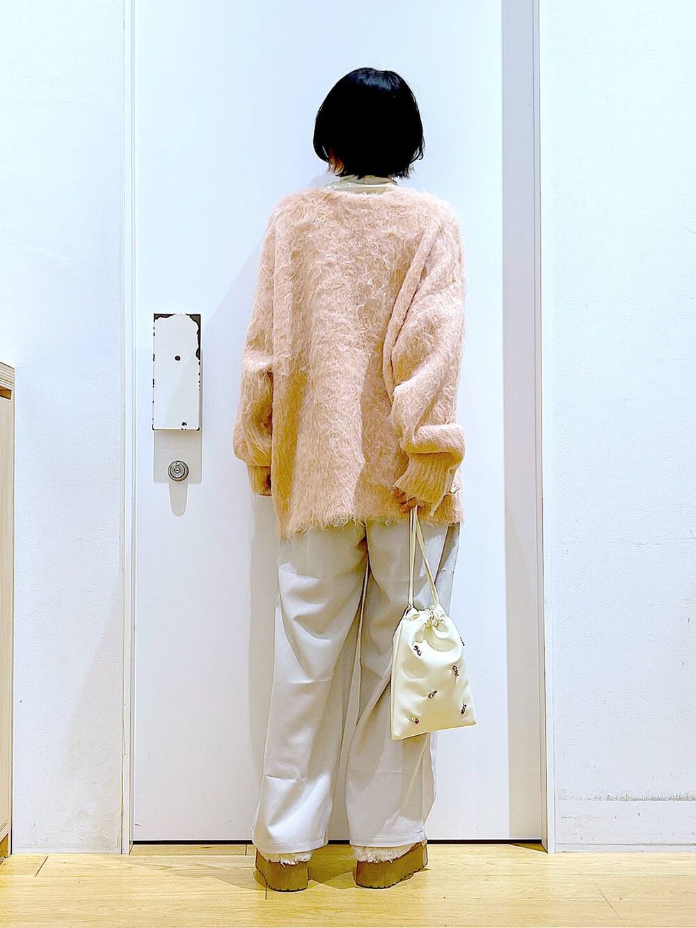 ピンク系のカーディガン/ボレロ、ホワイト系のショルダーバッグ、ホワイト系のTシャツ/カットソーを着用したレディースの冬コーディネートの5枚目の写真