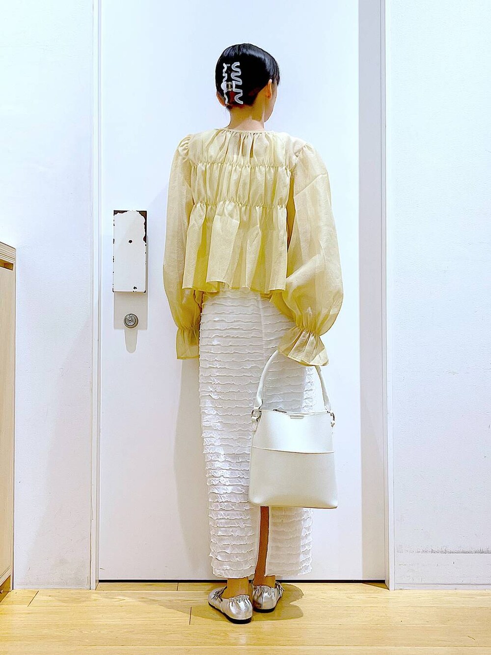 ホワイト系のベスト、ホワイト系のショルダーバッグ、ホワイト系のスカートを着用したレディースの秋コーディネートの5枚目の写真