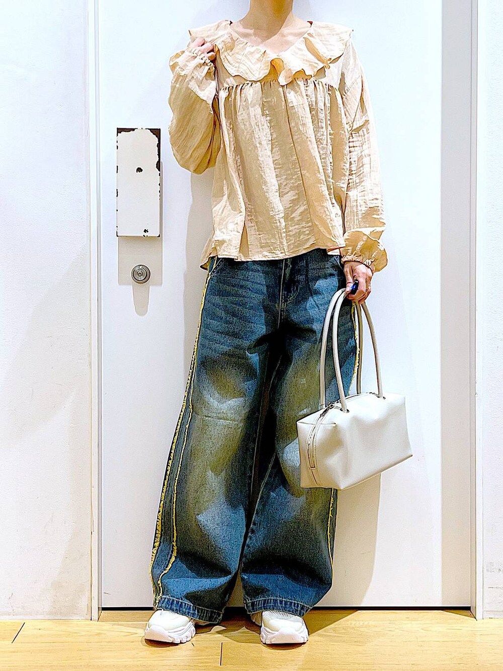 ホワイト系のボストンバッグ、ホワイト系のスニーカー、ブルー系のデニムパンツを着用したレディースの春コーディネートの6枚目の写真