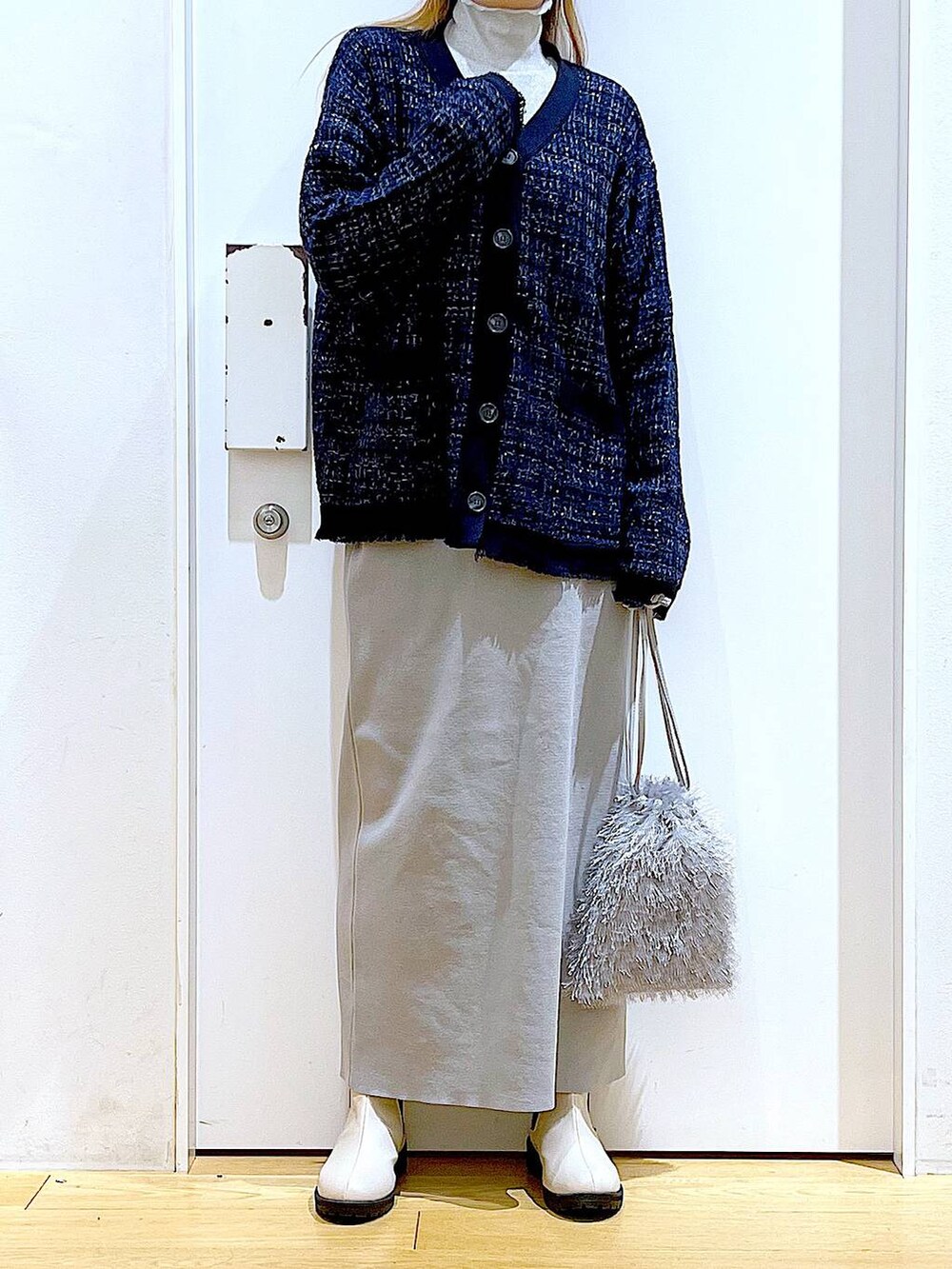 グレー系のTシャツ/カットソー、ブルー系のカーディガン/ボレロ、ベージュ系のブーツを着用したレディースの春コーディネートの6枚目の写真