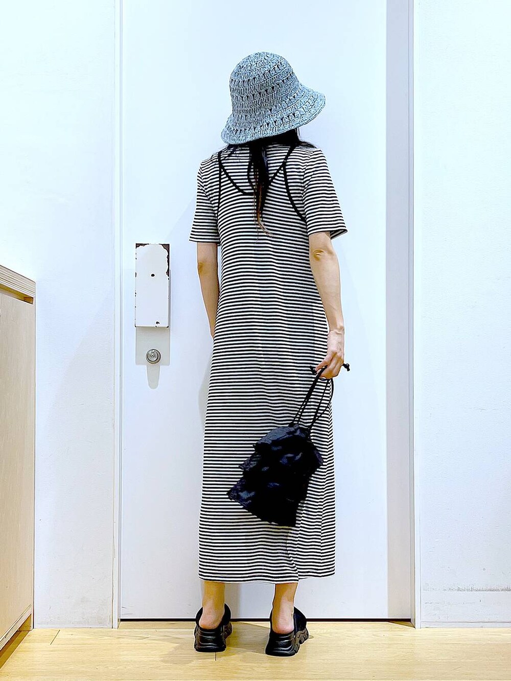 ブラック系のショルダーバッグ、ブラック系のサンダル、ブラック系のワンピースを着用したレディースの夏コーディネートの5枚目の写真