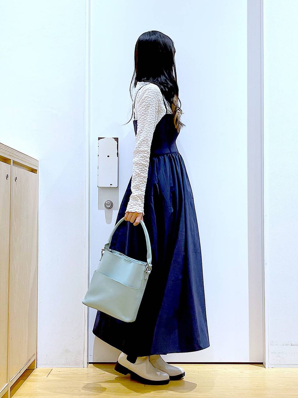 ホワイト系のTシャツ/カットソー、グリーン系のショルダーバッグ、ベージュ系のブーツを着用したレディースの春コーディネートの4枚目の写真