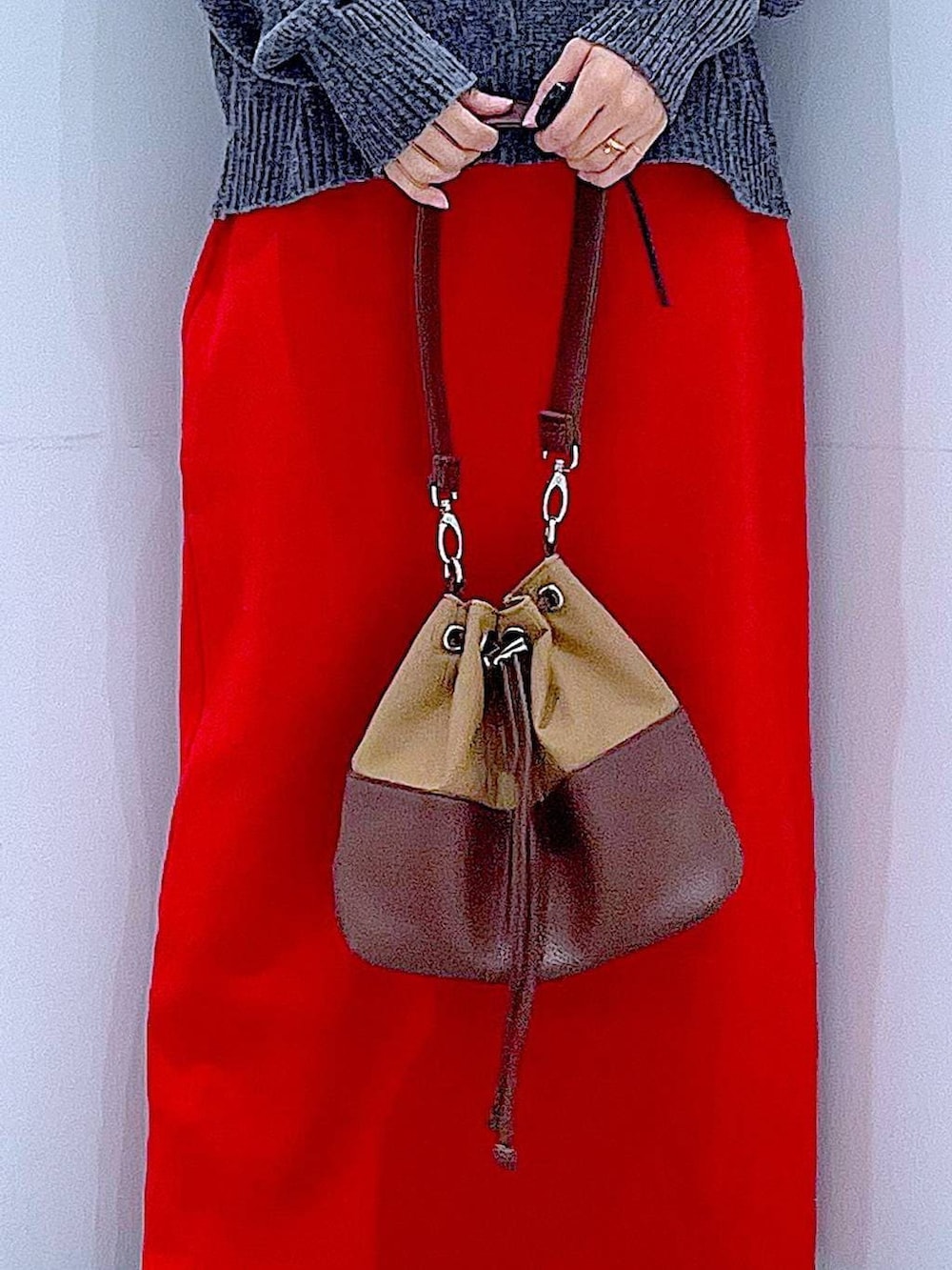 ベージュ系のショルダーバッグ、ブラック系のブーツ、グレー系のニット/セーターを着用したレディースの冬コーディネートの9枚目の写真