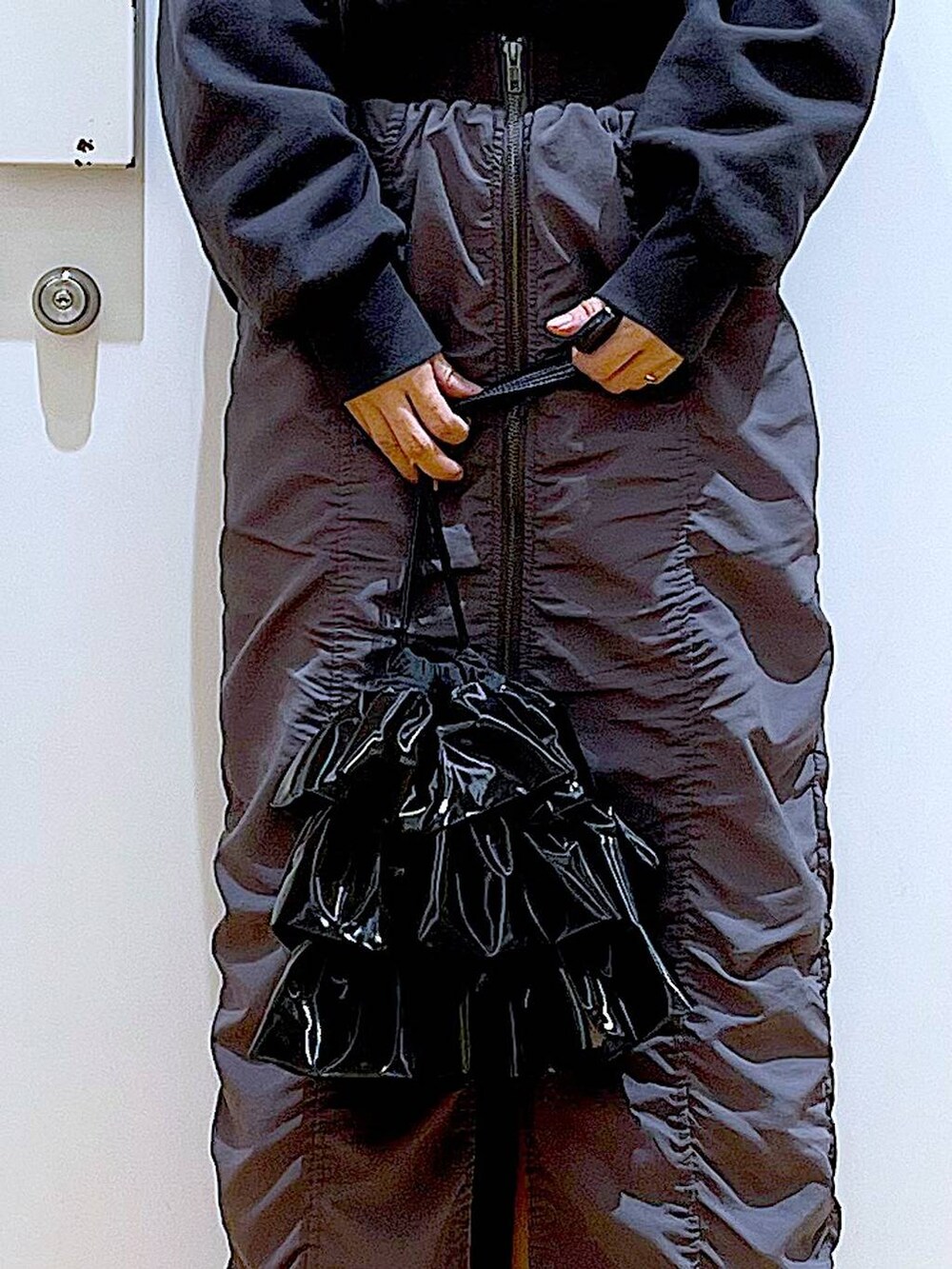 グレー系のスカート、ブラック系のショルダーバッグ、シルバー系のパンプスを着用したレディースの春コーディネートの9枚目の写真