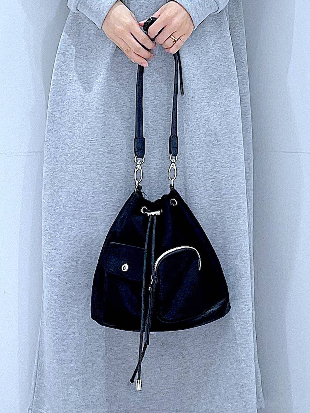 ブラック系のショルダーバッグ、グレー系のワンピース、ブラック系のキャップを着用したレディースの春コーディネートの9枚目の写真