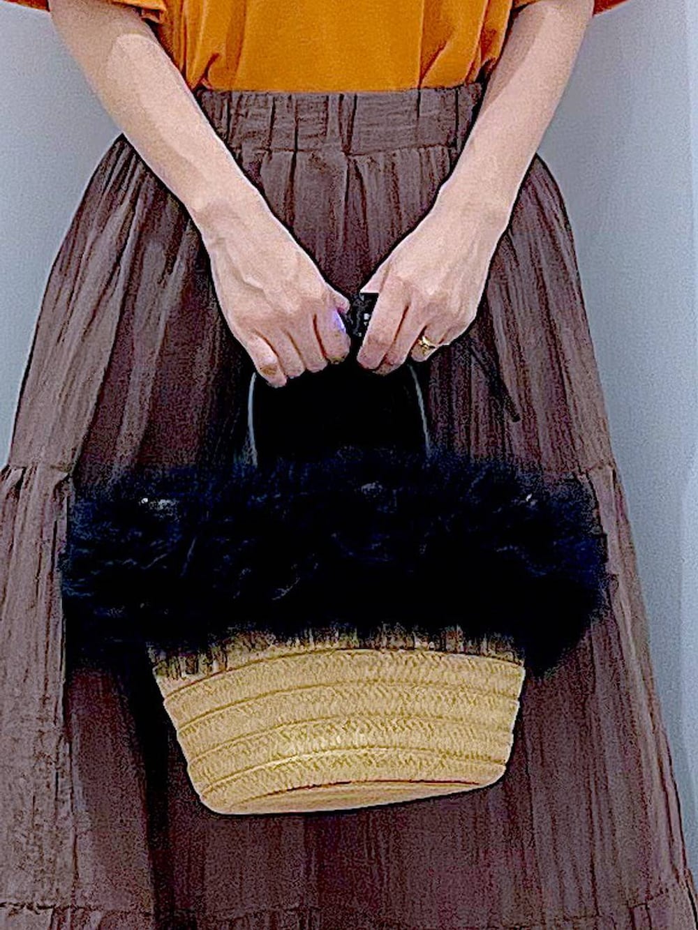 ベージュ系のショルダーバッグ、ブラック系のサンダル、オレンジ系のTシャツ/カットソーを着用したレディースの夏コーディネートの9枚目の写真