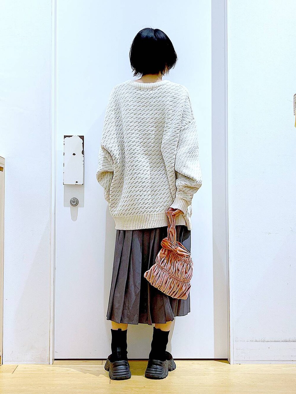 ベージュ系のニット/セーター、ピンク系のショルダーバッグ、ブラック系のブーツを着用したレディースの冬コーディネートの5枚目の写真