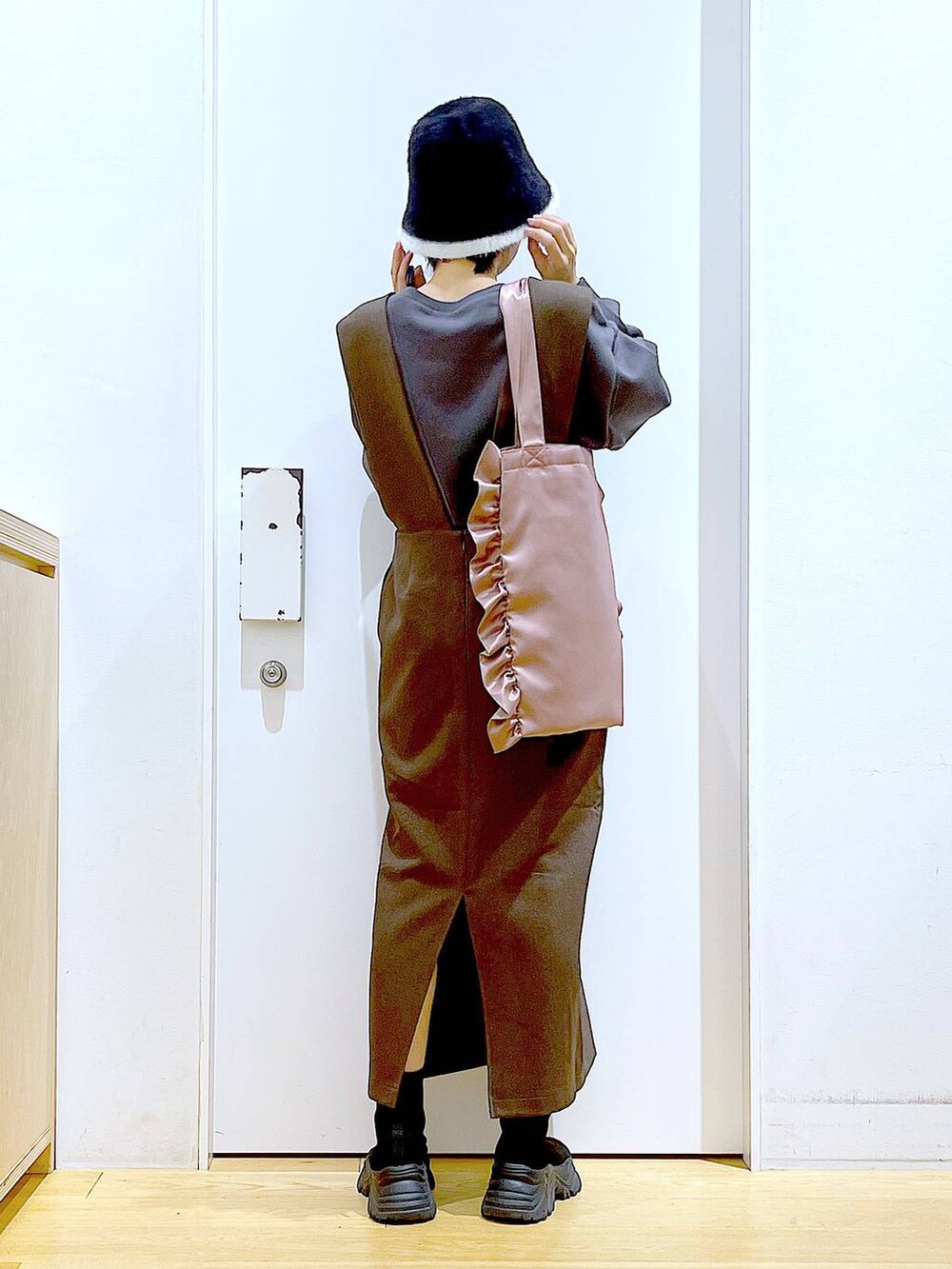 ブラック系のブーツ、ブラウン系のサロペット/オーバーオール、ピンク系のトートバッグを着用したレディースの冬コーディネートの5枚目の写真
