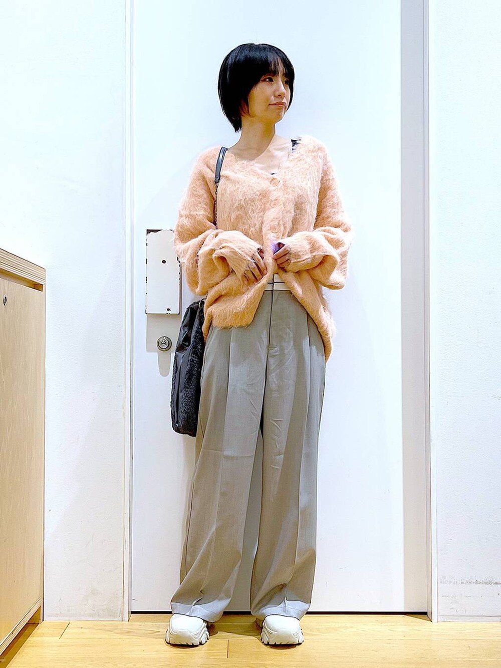 ピンク系のカーディガン/ボレロ、グレー系のショルダーバッグ、ベージュ系のブーツを着用したレディースの冬コーディネートの2枚目の写真