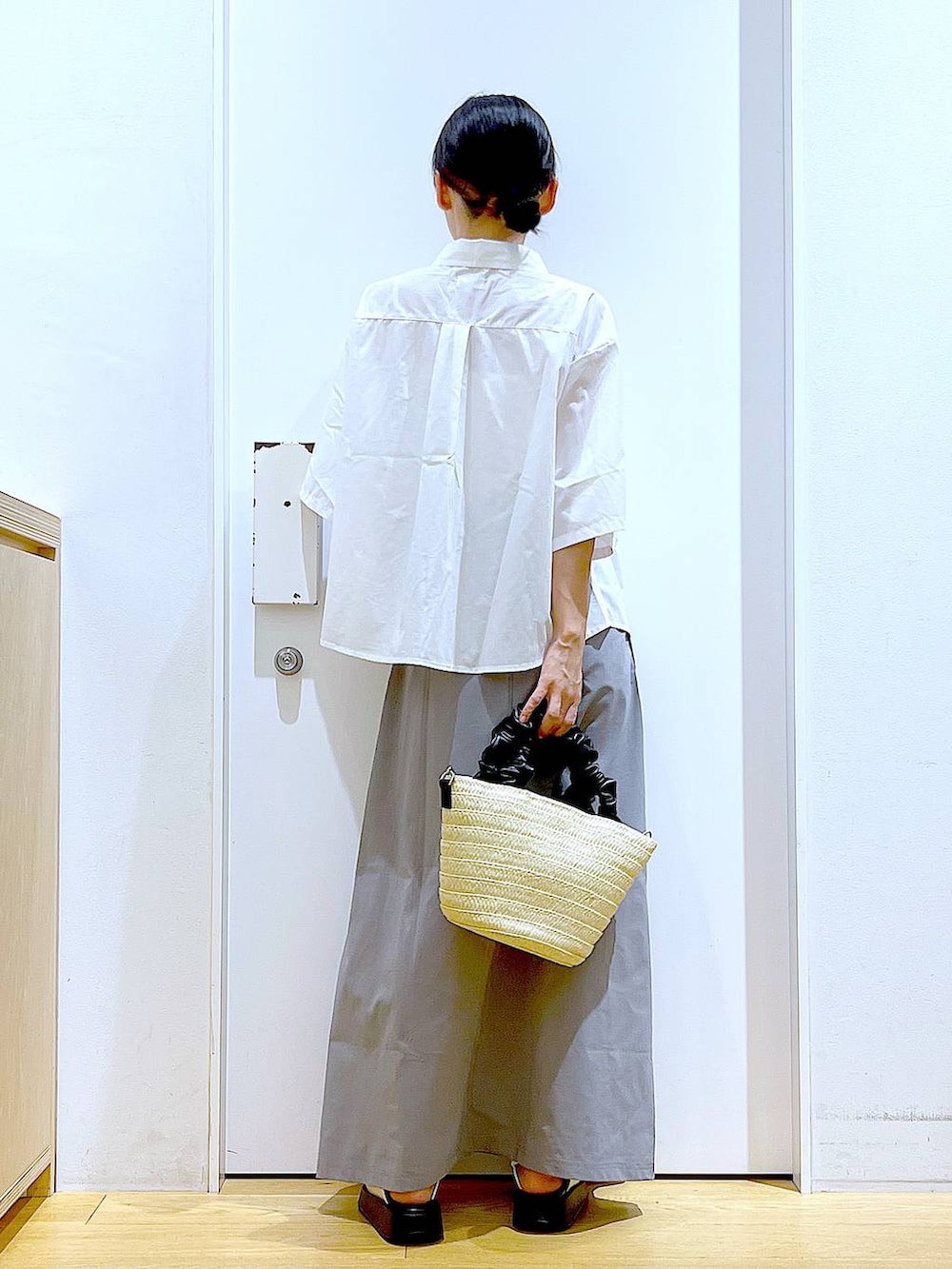 ホワイト系のサンダル、ホワイト系のショルダーバッグ、グレー系のスカートを着用したレディースの夏コーディネートの5枚目の写真