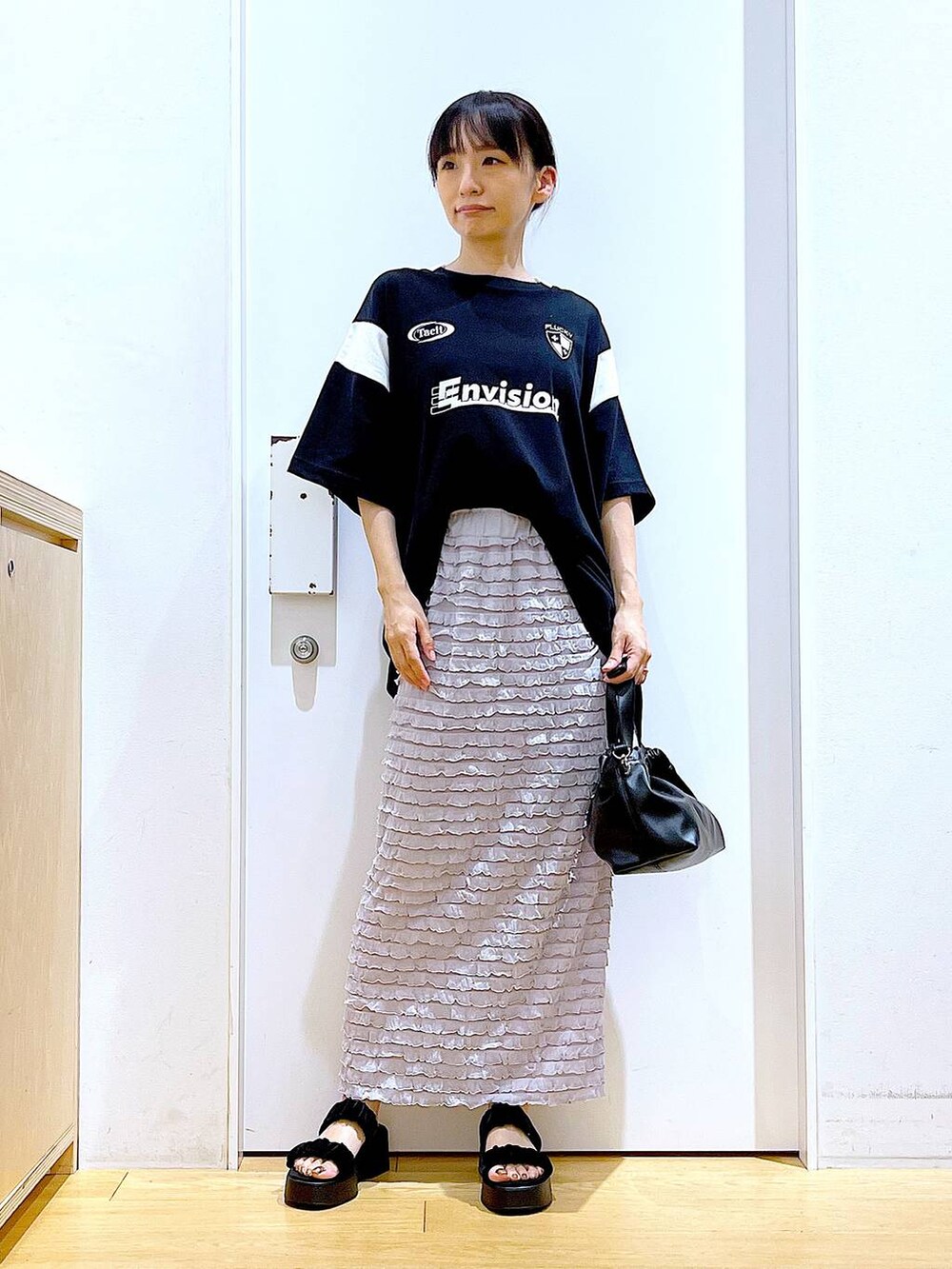 ブラック系のサンダル、ブラック系のショルダーバッグ、ブラック系のTシャツ/カットソーを着用したレディースの夏コーディネートの2枚目の写真