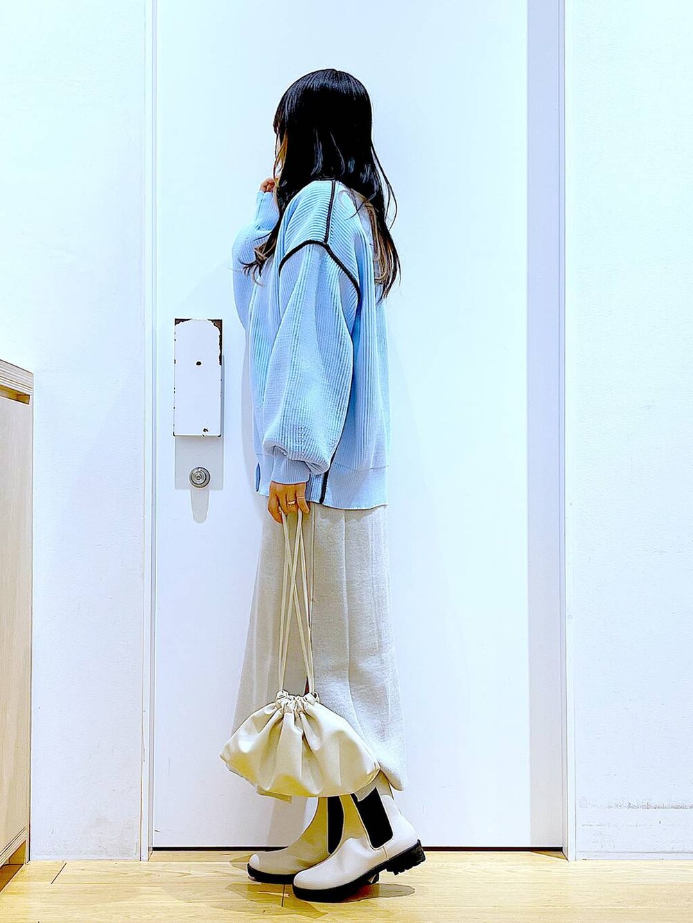 グレー系のスカート、その他のニット/セーター、ベージュ系のブーツを着用したレディースの春コーディネートの3枚目の写真