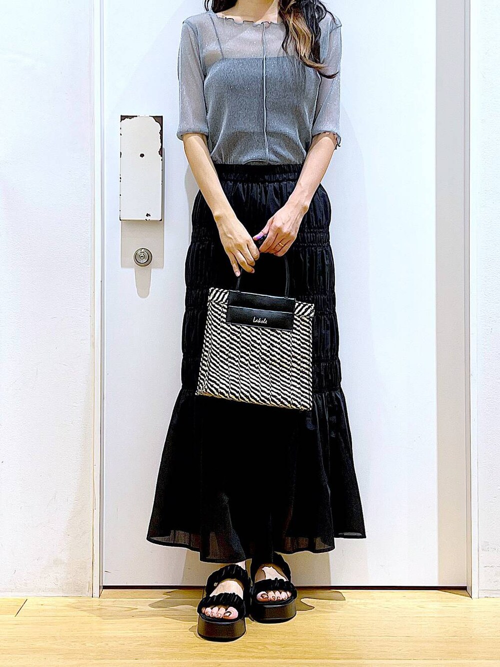 ブラック系のサンダル、ブラック系のショルダーバッグ、ブルー系のTシャツ/カットソーを着用したレディースの夏コーディネートの6枚目の写真