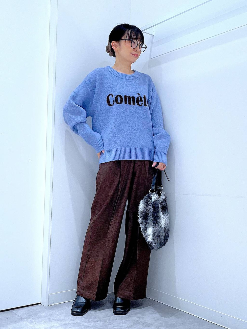 ブラック系のブーツ、ブラウン系のスラックス、ブラック系のショルダーバッグを着用したレディースの冬コーディネートの2枚目の写真