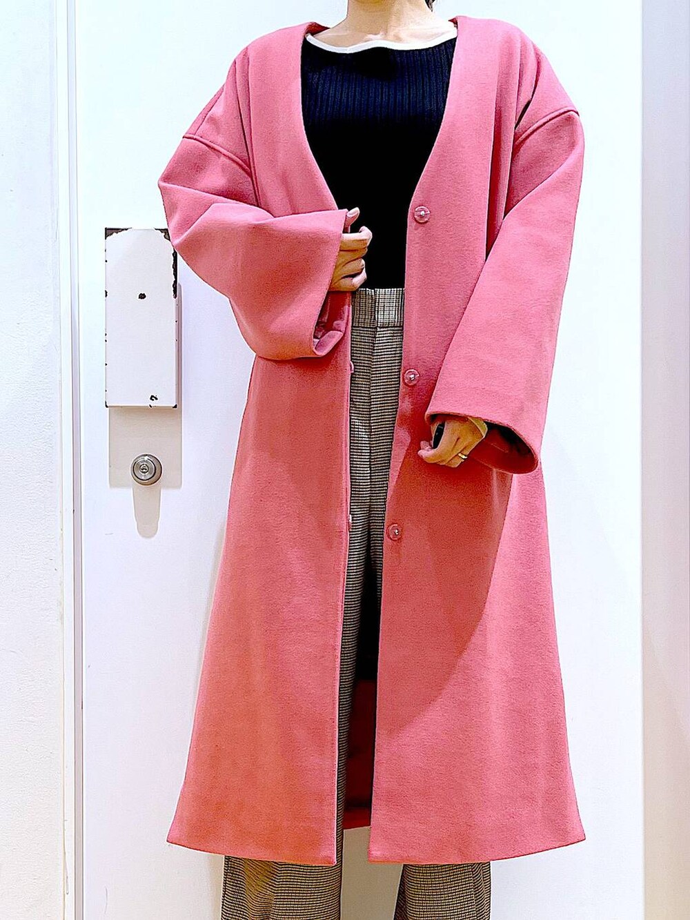 ブラック系のショルダーバッグ、ブラック系のニット/セーター、ベージュ系のスラックスを着用したレディースの冬コーディネートの7枚目の写真