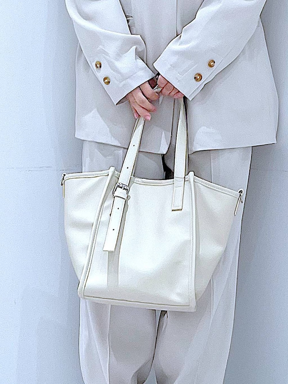 ブラック系のブーツ、ホワイト系のトートバッグ、ベージュ系のノーカラージャケットを着用したレディースの冬コーディネートの9枚目の写真