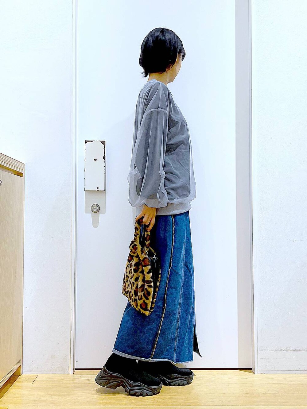 その他のショルダーバッグ、ブルー系のデニムスカート、ブラック系のブーツを着用したレディースの冬コーディネートの4枚目の写真