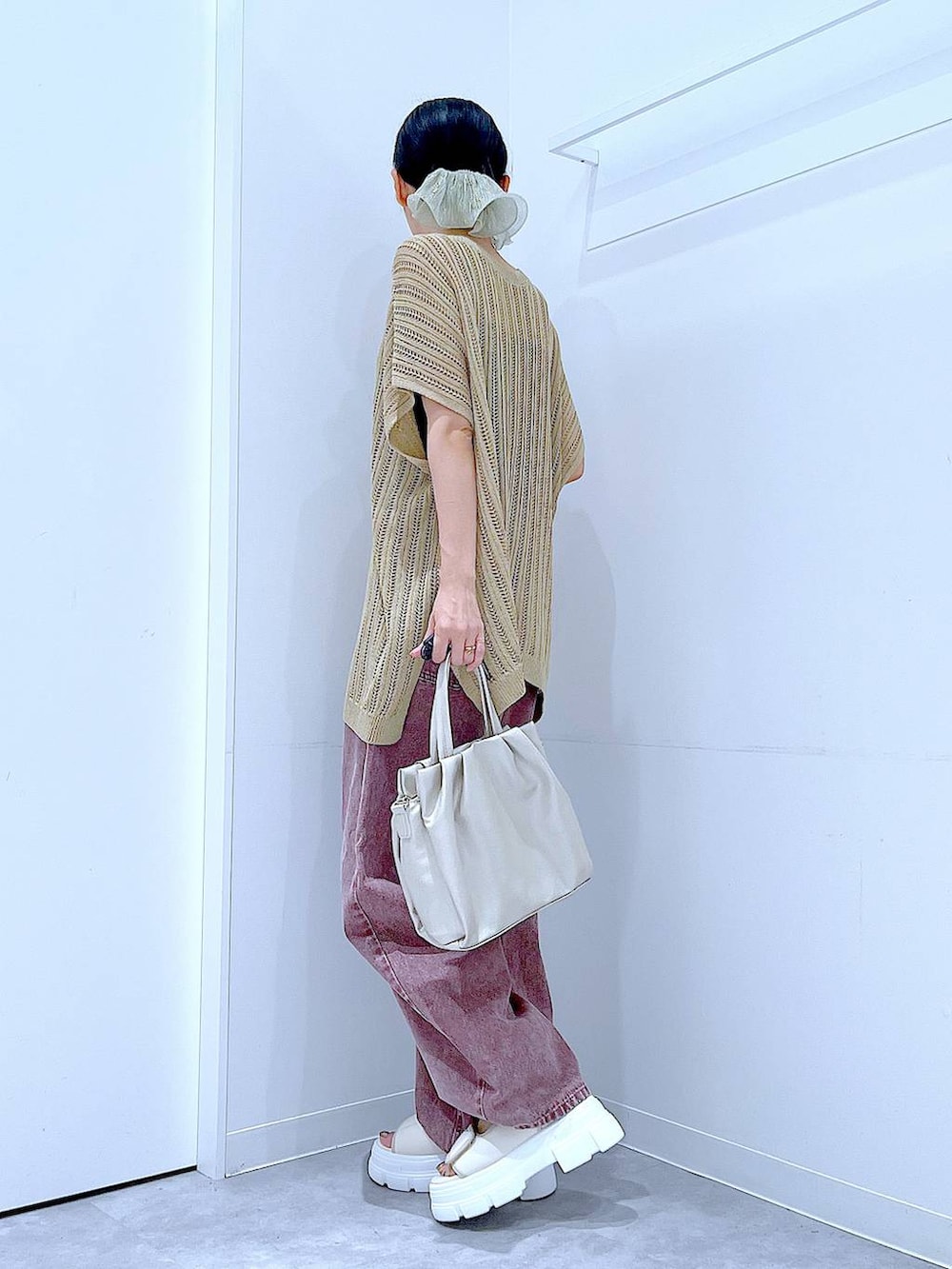 レッド系のデニムパンツ、ホワイト系のサンダル、ホワイト系のハンドバッグを着用したレディースの夏コーディネートの3枚目の写真