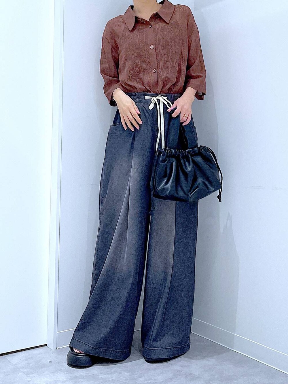 ブラウン系のシャツ/ブラウス、ブラック系のショルダーバッグ、ブラック系のデニムパンツを着用したレディースの夏コーディネートの6枚目の写真