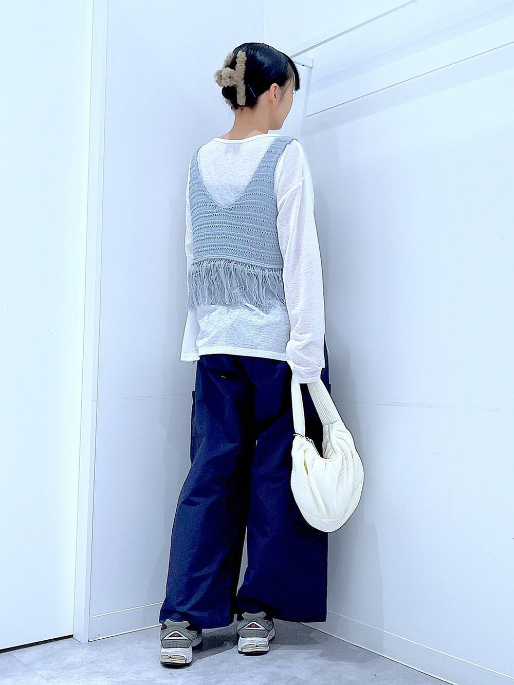 ブルー系のベスト、ホワイト系のショルダーバッグ、ホワイト系のTシャツ/カットソーを着用したレディースの春コーディネートの5枚目の写真