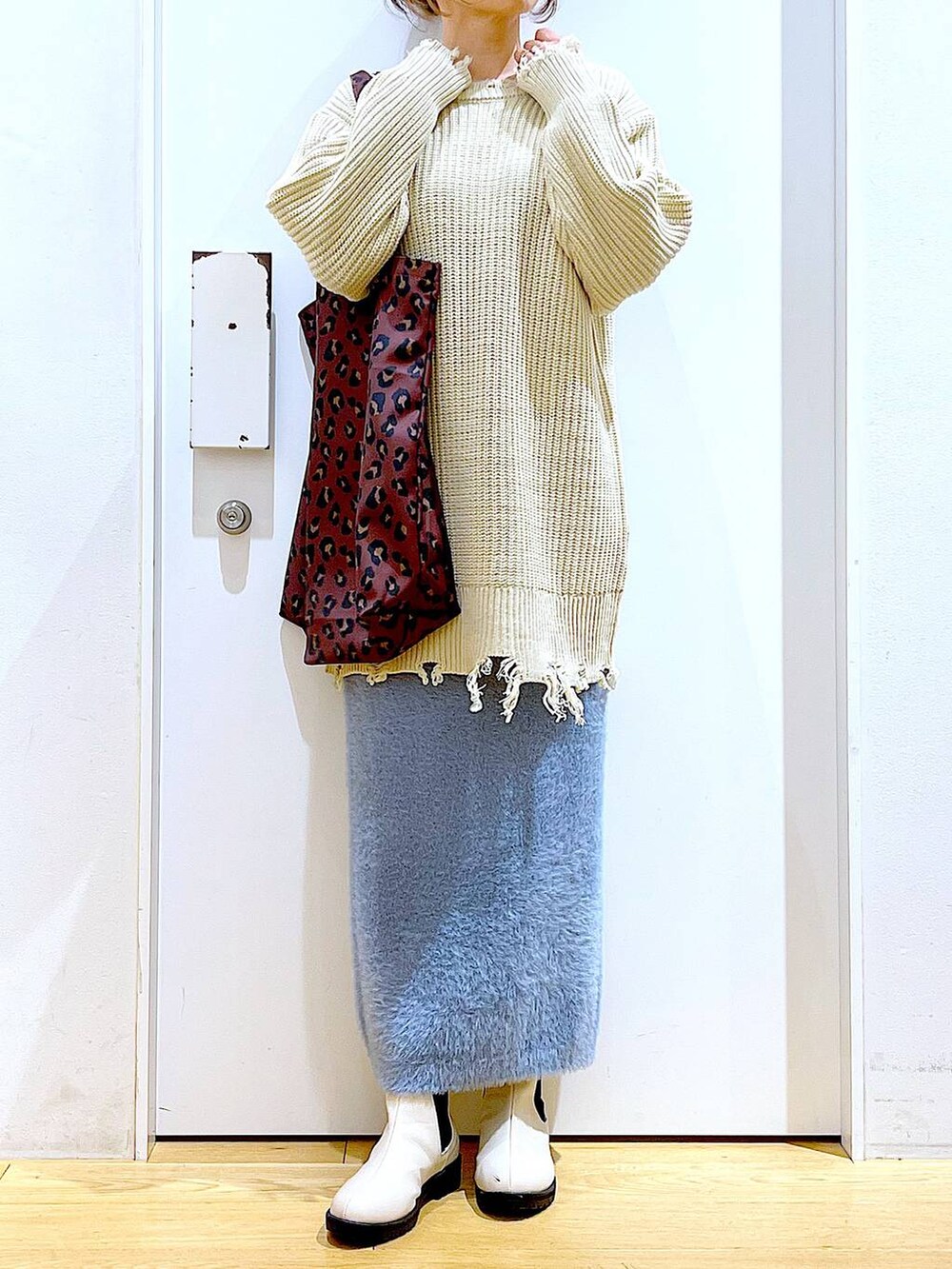 ベージュ系のブーツ、その他のトートバッグ、ブルー系のスカートを着用したレディースの冬コーディネートの6枚目の写真