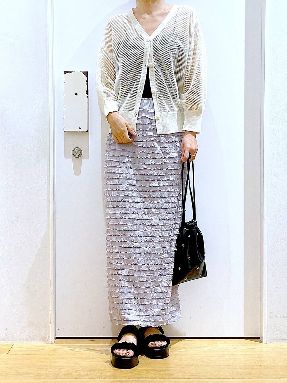 ブラック系のサンダル、ブラック系のショルダーバッグ、ホワイト系のカーディガン/ボレロを着用したレディースの夏コーディネートの6枚目の写真