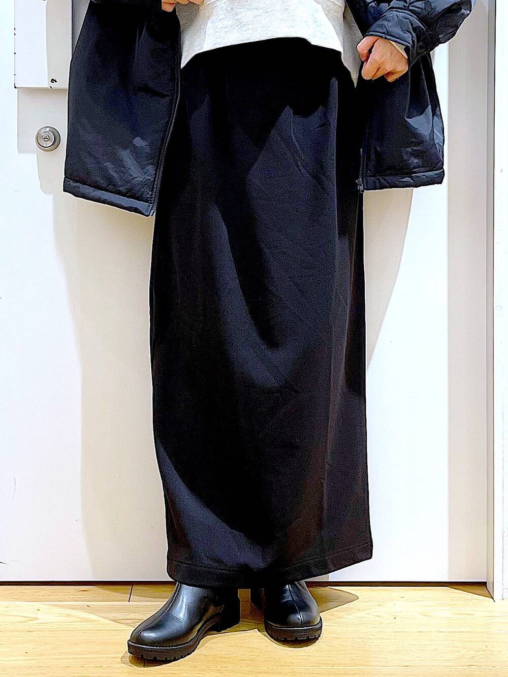 ブラック系のブルゾン、ブラック系のブーツ、ブラウン系のクラッチバッグを着用したレディースの冬コーディネートの8枚目の写真