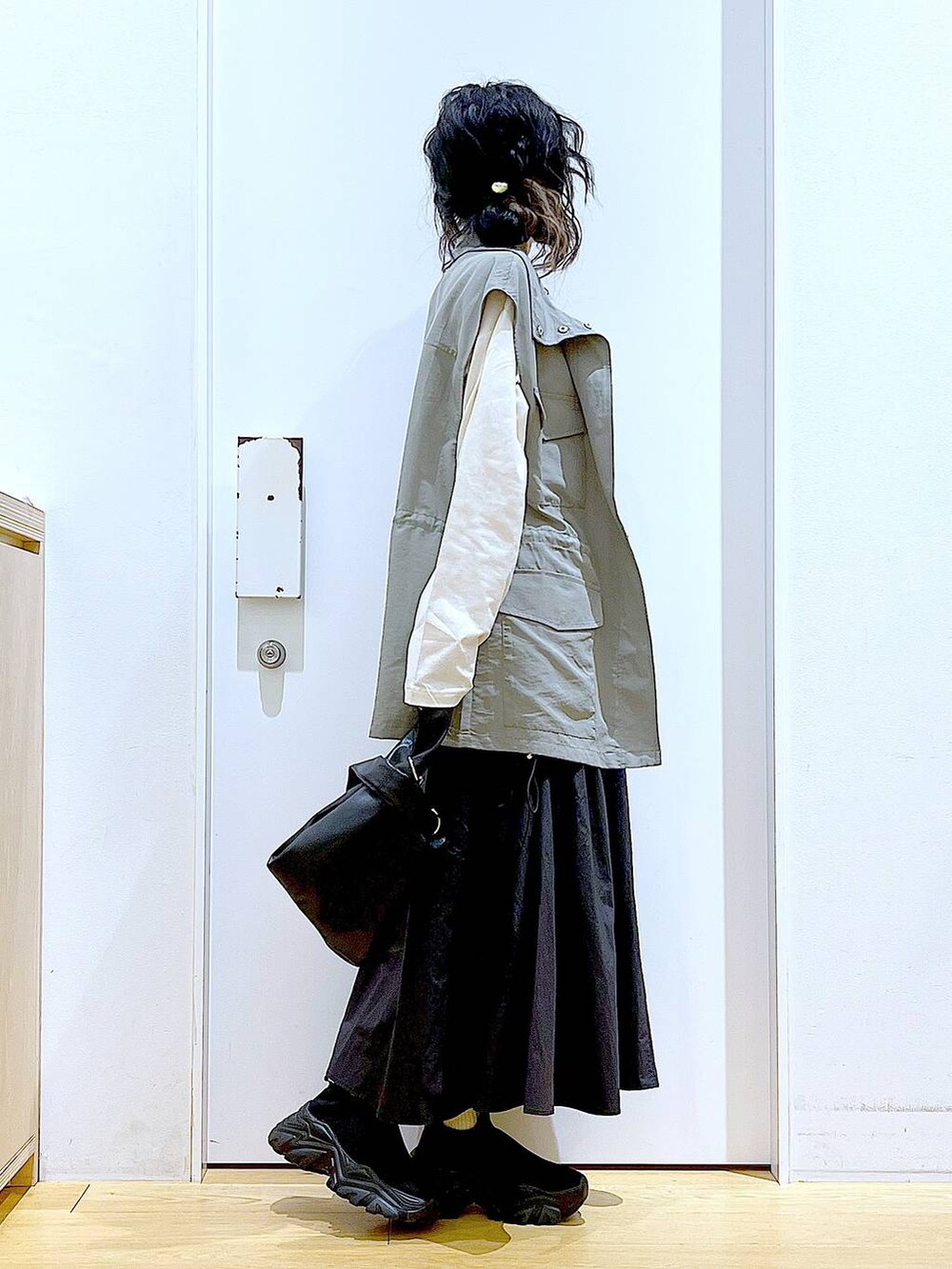 ブラック系のショルダーバッグ、ブラック系のスニーカー、ブラック系のスカートを着用したレディースの春コーディネートの4枚目の写真