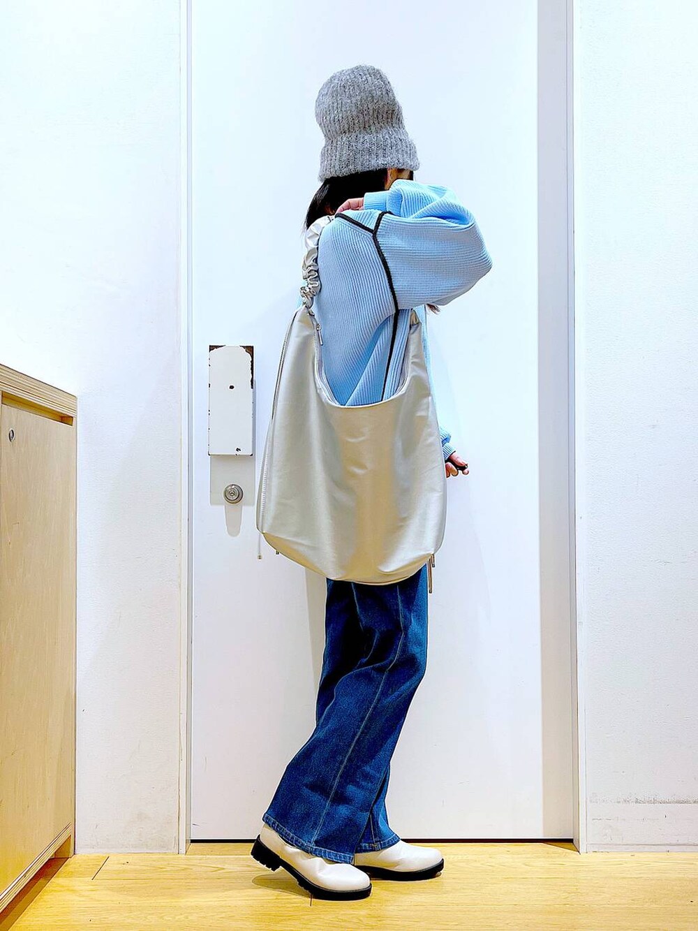 ブルー系のデニムパンツ、ベージュ系のブーツ、ベージュ系のニット/セーターを着用したレディースの冬コーディネートの4枚目の写真