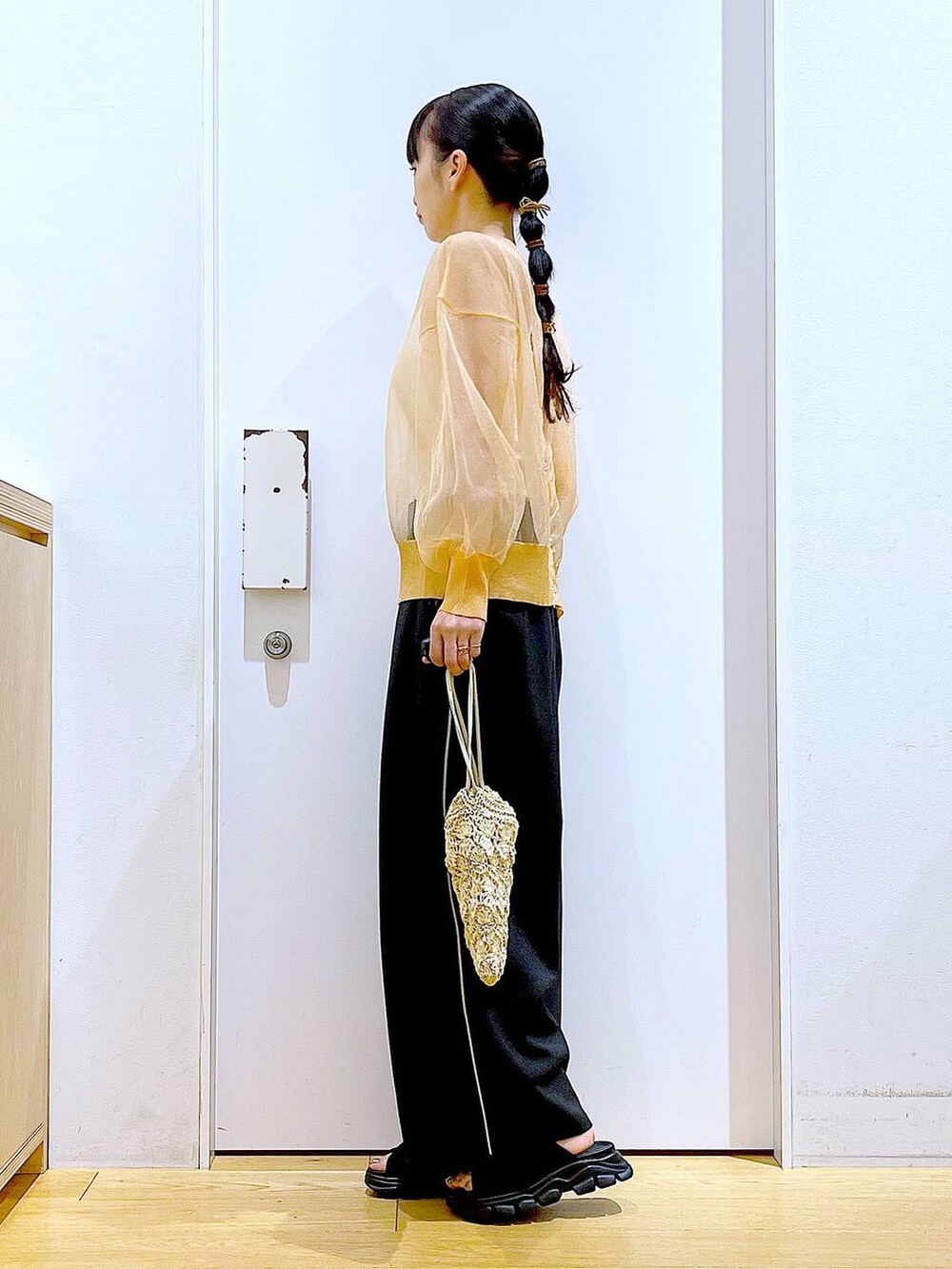 ブラック系のサンダル、オレンジ系のカーディガン/ボレロ、ベージュ系のショルダーバッグを着用したレディースの夏コーディネートの3枚目の写真