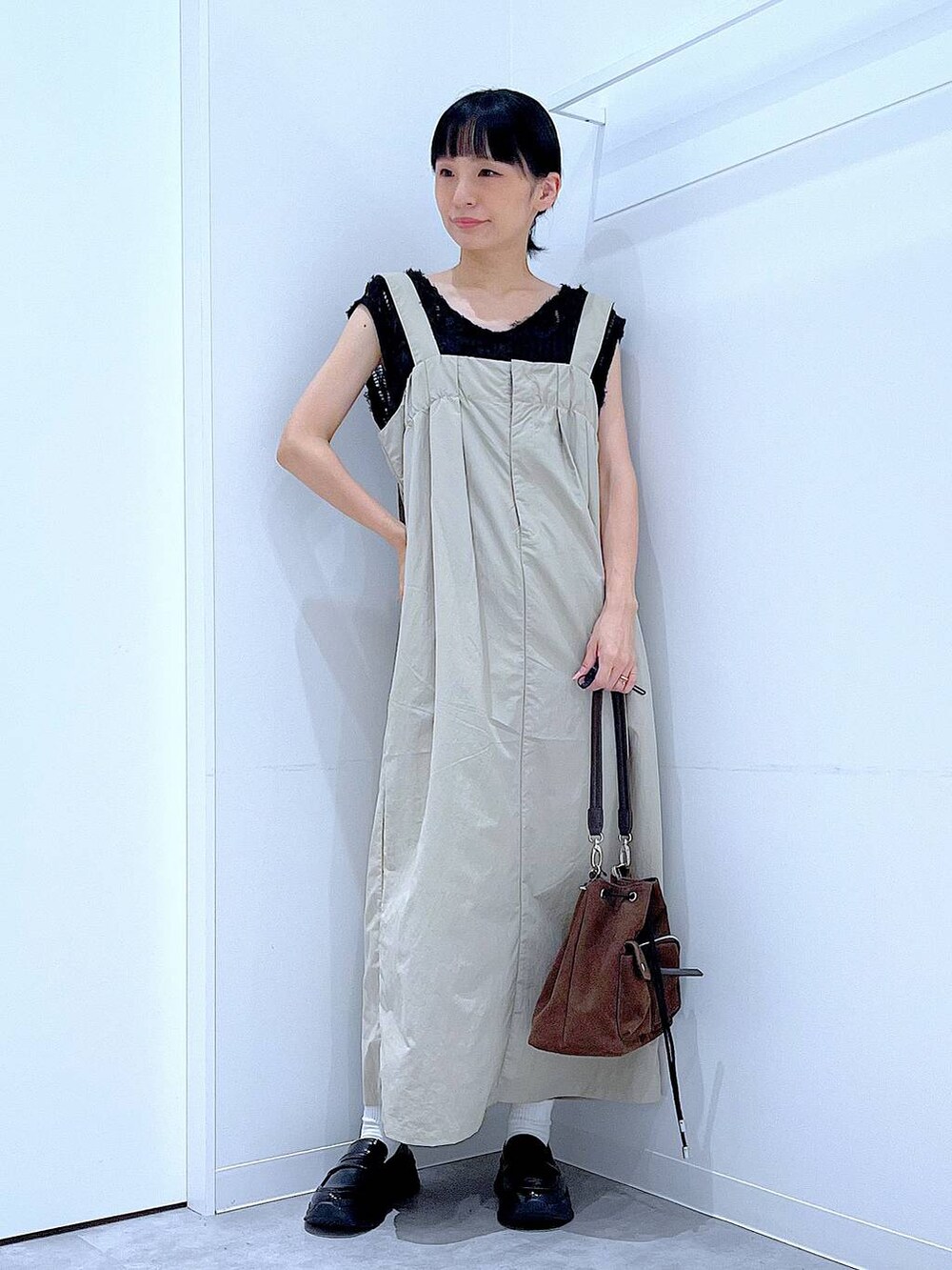 ブラック系のローファー、ブラウン系のショルダーバッグ、グレー系のワンピースを着用したレディースの秋コーディネートの2枚目の写真