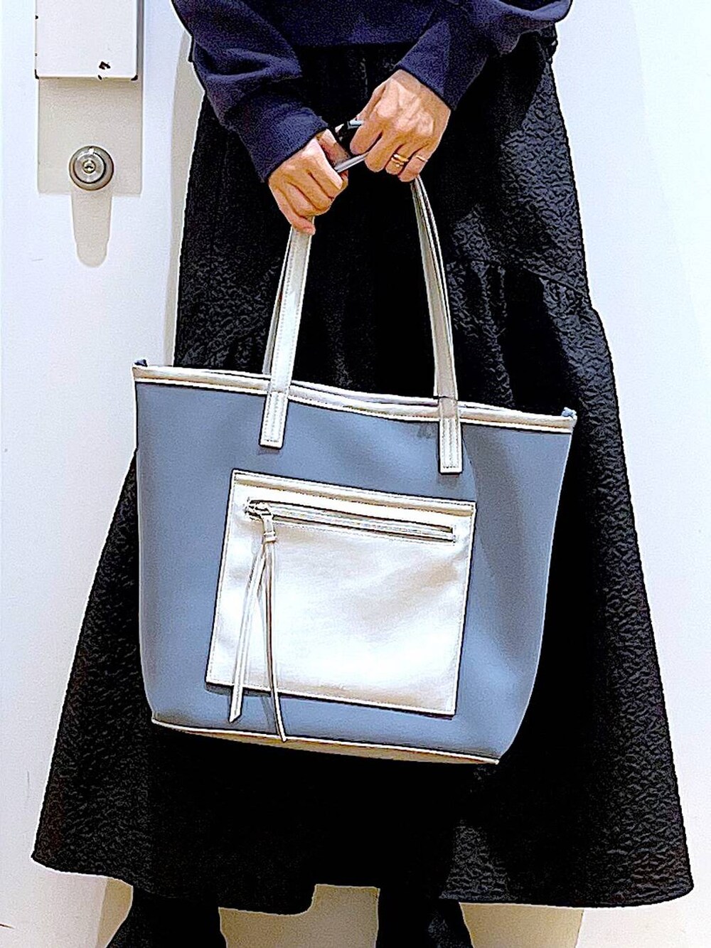 グレー系のトートバッグ、ブラック系のブーツ、グレー系のスウェットを着用したレディースの冬コーディネートの9枚目の写真