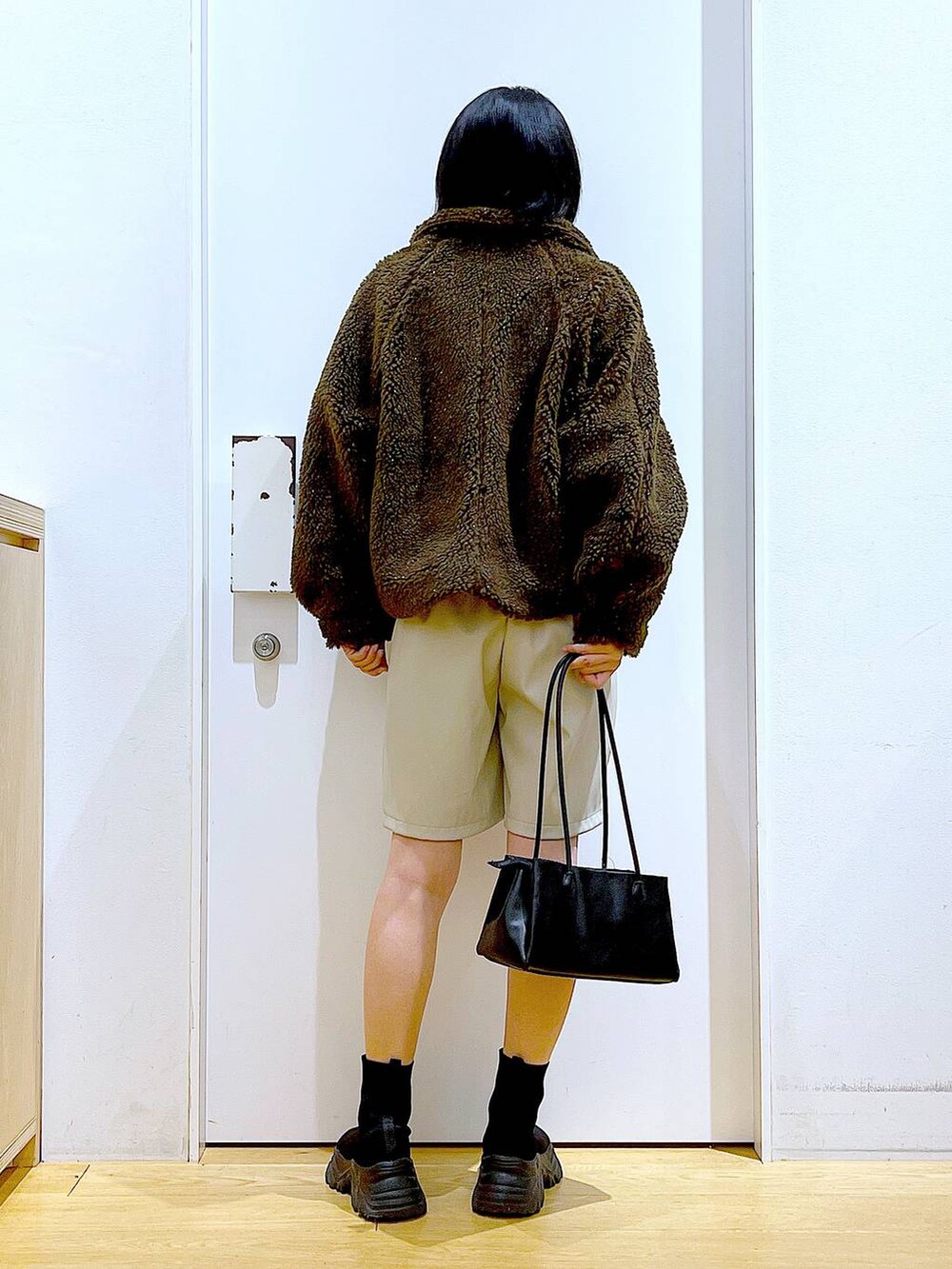 ブルー系のニット/セーター、ブラック系のトートバッグ、ブラック系のブーツを着用したレディースの冬コーディネートの5枚目の写真