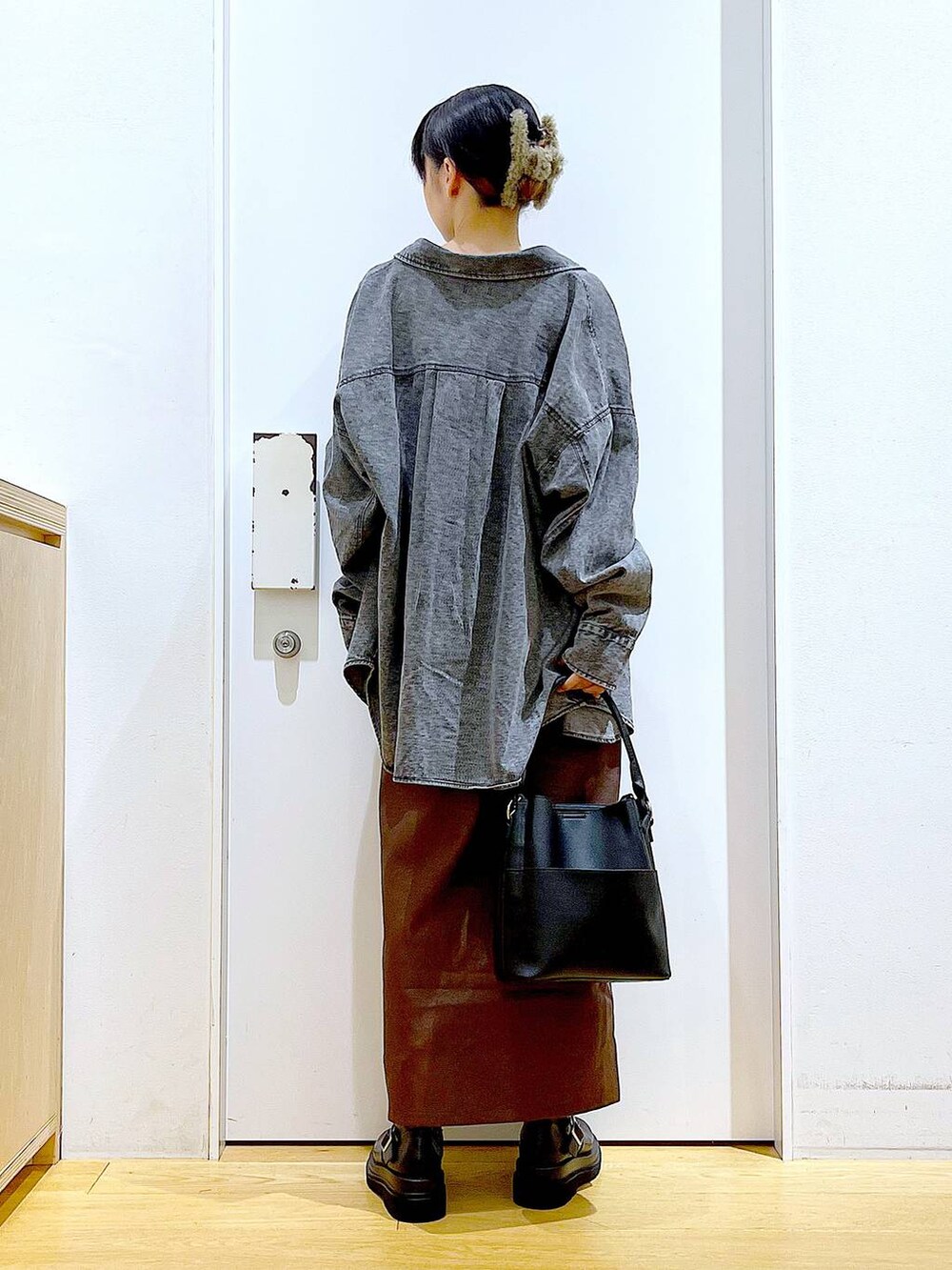 ブラウン系のスカート、ブラック系のニット/セーター、ブラック系のショルダーバッグを着用したレディースの秋コーディネートの5枚目の写真