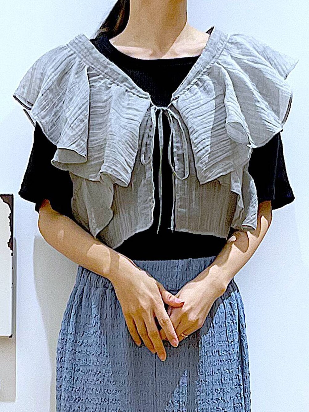 ブラック系のショルダーバッグ、ブルー系のスカート、ブラック系のTシャツ/カットソーを着用したレディースの夏コーディネートの7枚目の写真